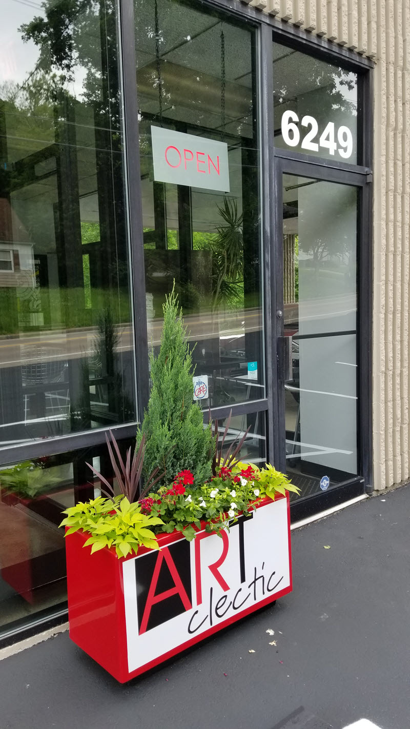 Front entrance with a planter with the ARTclectic Logo on it